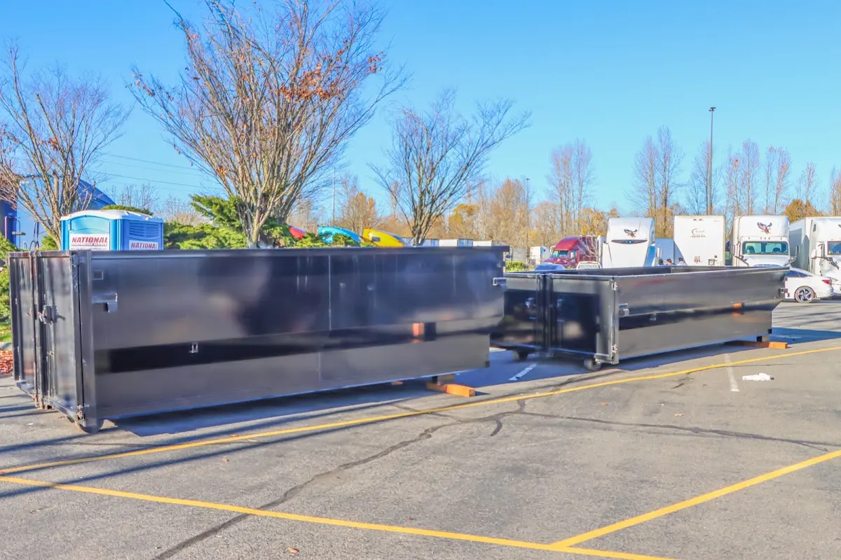 Professional dumpster rental service with roll-off container on residential driveway in Ensley